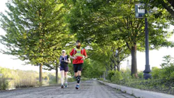 Former Woodstock, IL, firefighter Ryan Mains runs with pace runner Leann McMonigan along the Fox River Trail on Saturday in Elgin. After months of training, he was making an 80-mile run to raise $18,000 to help first responders struggling with PTSD.