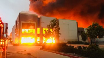 Firefighters worked to extinguish a massive three-alarm blaze that broke out at an Amazon distribution center in Redlands, CA, early Friday.