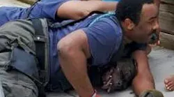 Two Washington, D.C., firefighters hold down two dogs that began attacking civilians at a fire scene Thursday.
