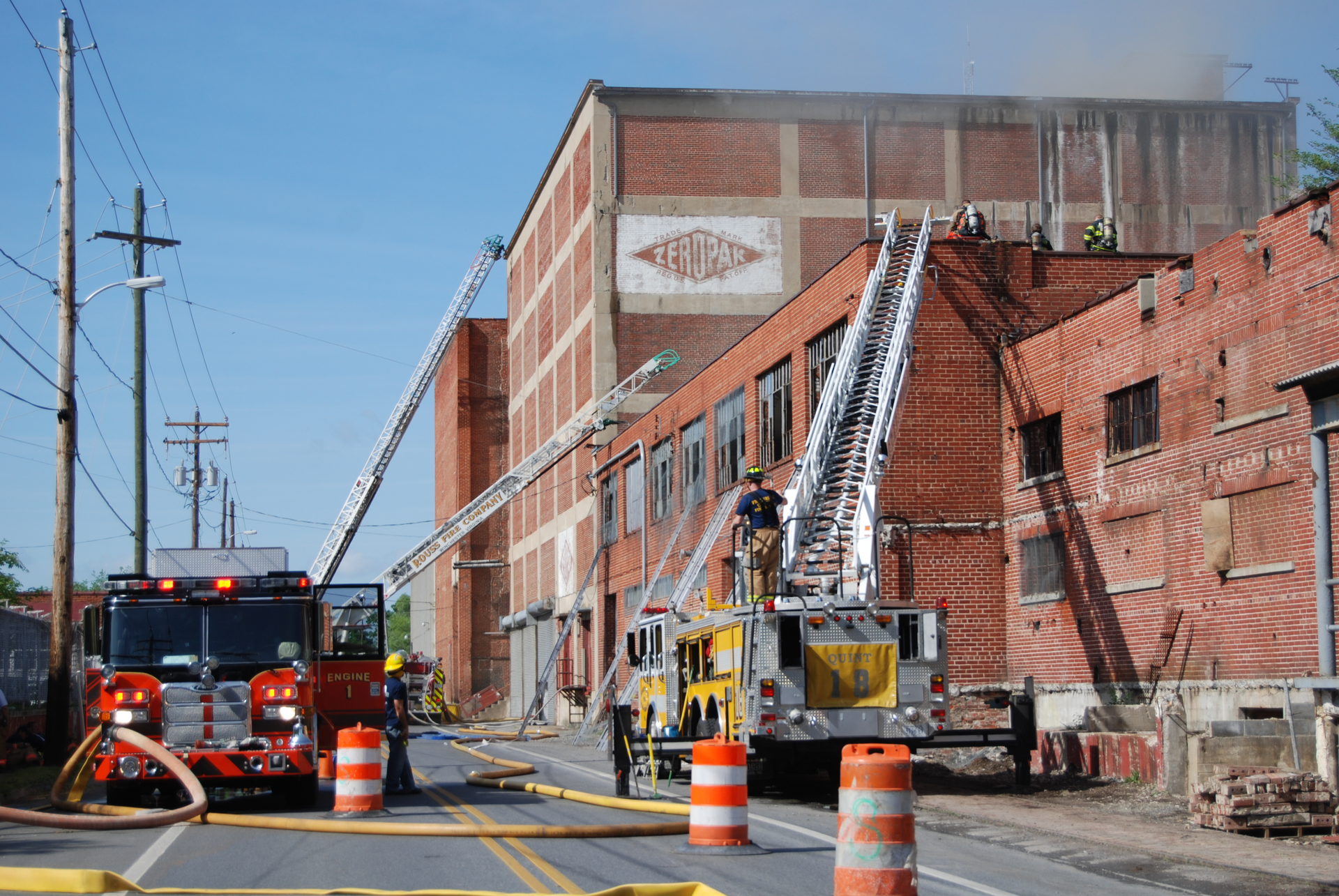 Apparatus placement on the fireground is affected by the size of engine company units and the aerial device vertical and horizontal reach. Note how the engine company took a position away from the building to provide clear access for the three ladder trucks and the placement of the aerial devices on two sides of the structure.