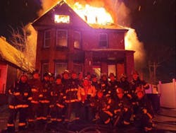 Detroit firefighters pose in front of a burning home on New Year's Eve in a photo that was posted on social media. Detroit firefighters pose in front of a burning home on New Year's Eve in a photo that was posted on social media.