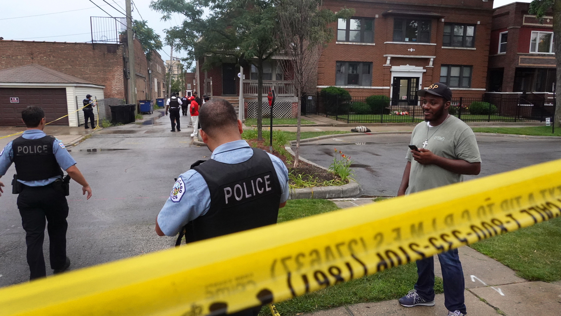 Chicago police secure the scene of a shooting in the Auburn Gresham neighborhood Tuesday. At least 14 people were taken to area hospitals after gunfire was exchanged outside of a funeral home.