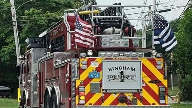 A Hingham, MA, fire apparatus displays a 'thin blue line' flag supporting police officers.