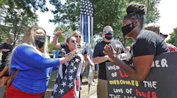 Hingham, MA, resident Anne Pungitore (left) talks Tuesday with Black Lives Matter protester Tru Edwards (right) who came from Boston to counter protest a rally held to object to town officials asking for the removal of 'thin blue line' flags from fire apparatus.