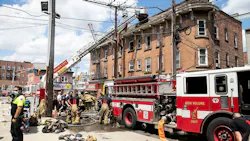 Firefighters rescued a woman and a dog from a three-alarm blaze that broke out at a Jersey City, NJ, apartment building and injured four firefighters Tuesday.