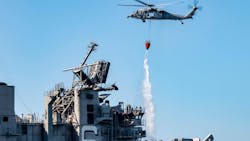 An MH-60S Sea Hawk helicopter from the 'Merlins' of Helicopter Sea Combat Squadron (HSC) 3, provides aerial firefighting support Tuesday to fight the fire aboard the amphibious assault ship USS Bonhomme Richard. An MH-60S Sea Hawk helicopter from the 'Merlins' of Helicopter Sea Combat Squadron (HSC) 3, provides aerial firefighting support Tuesday to fight the fire aboard the amphibious assault ship USS Bonhomme Richard.