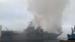 A firefighting helicopter flies in Monday to drop water on a U.S. Navy ship still burning in San Diego. A firefighting helicopter flies in Monday to drop water on a U.S. Navy ship still burning in San Diego.