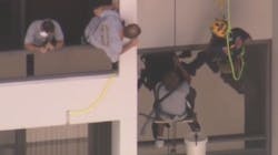 A Palm Beach County, FL, firefighter rappelled down the side of a building to rescue a window washer who was dangling about 15 stories up for nearly an hour Monday.