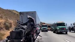 Flames from a tractor-trailer crash along the 15 Freeway in the Cajon Pass sparked a 10-acre brush fire after spreading to a drainage ditch Sunday. Flames from a tractor-trailer crash along the 15 Freeway in the Cajon Pass sparked a 10-acre brush fire after spreading to a drainage ditch Sunday.