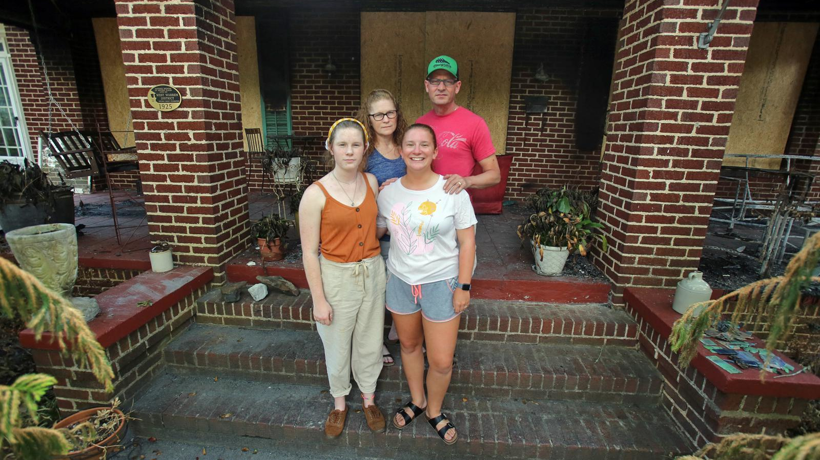 Faith and Shelby, NC, Fire Chief William Hunt stand outside their damaged home with daughters Grace (left) and Cana on Wednesday. The Hunt home was one of multiple fires believed to be arson this month.