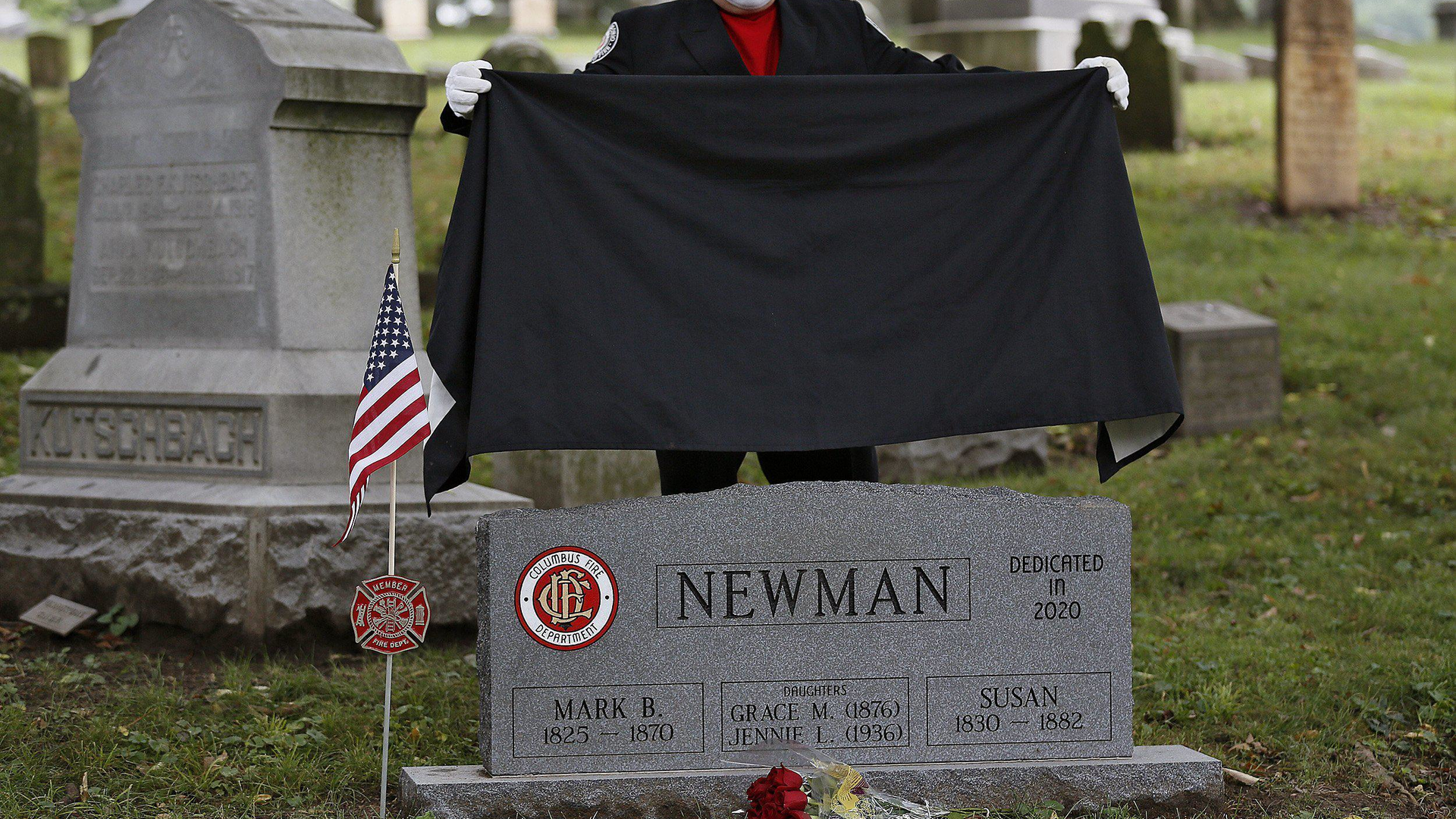 Columbus, OH, firefighter Stephen Cox unveils the new headstone for Columbus firefighter Mark Newman during a ceremony at Green Lawn Cemetery on Tuesday.