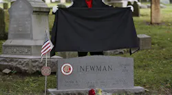 Columbus, OH, firefighter Stephen Cox unveils the new headstone for Columbus firefighter Mark Newman during a ceremony at Green Lawn Cemetery on Tuesday.