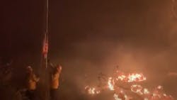 Firefighters save a U.S. flag Wednesday caught in the Lake Fire that has burned more than 10,000 acres in the Lake Hughes, CA.