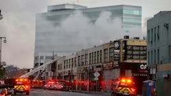 Firefighters at the scene of a commercial fire in downtown Los Angeles that has injured 11 firefighters and left multiple buildings ablaze May 16. The owners connected to the massive downtown explosion face 300 criminal charges.