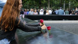 A mourner places a rose for a loved one during the 2019 anniversary ceremony in New York City for the Sept. 11 attacks.