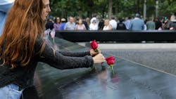 A mourner places a rose for a loved one during the 2019 anniversary ceremony in New York City for the Sept. 11 attacks.
