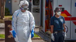 Firefighter/Paramedic William Fletcher (left) wears COVID-19 personal protective equipment and EMT Mya Jones wears basic level personal protective equipment during a press conference March 31 in the parking lot of Northwest Community Pool in St. Petersburg, FL. St. Petersburg Fire Rescue, in partnership with Sunstar Paramedics, has developed a strategy to deploy COVID-19 Strike Teams.
