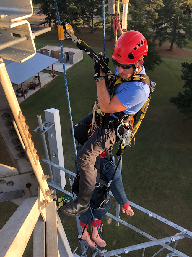 During training, a rescuer just performed a pick-off of a patient on fall-arrest who fell outside of an antenna boom. The rescuer created a small mainline deviation in the antenna and picked off the patient using his Grillon as a crude 2:1 and pick-off connection. The rescuer now is evacuating the patient to the ground with a mainline and ASAP back-up line.