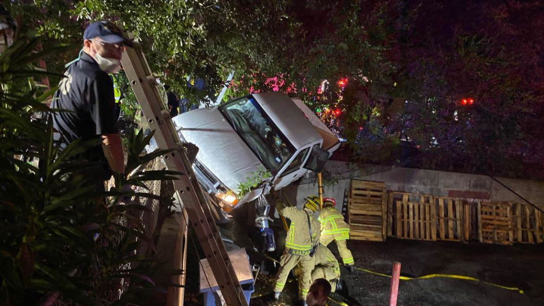 Austin, TX, firefighters rescued a woman who was trapped in her pickup truck between two retaining walls following a one-vehicle crash early Tuesday.