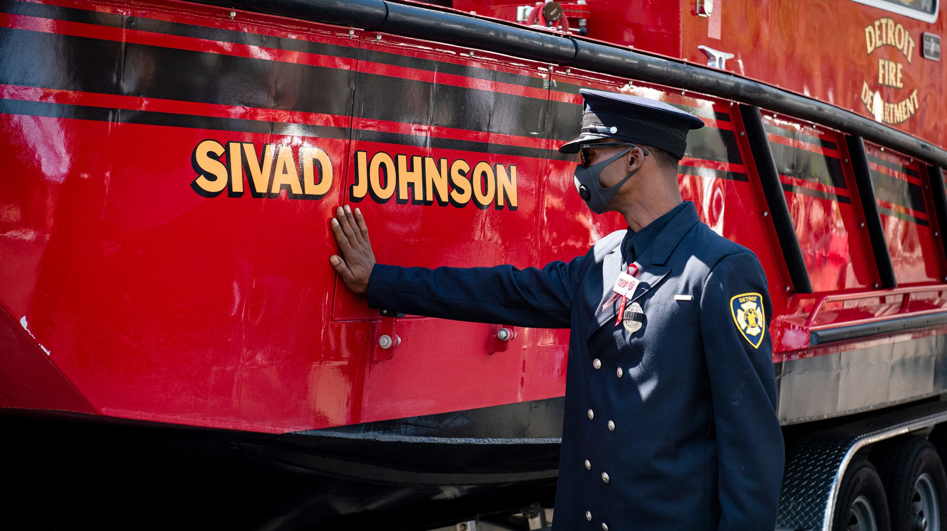 Detroit firefighter Jamal Johnson touches the new fire and rescue boat named after his older brother and fellow firefighter Sgt. Sivad Johnson during a memorial service outside the Detroit Public Safety Headquarters on Monday. Johnson died while trying to rescue two girls who were drowning Aug. 21 in the Detroit River at the Belle Isle Beach.