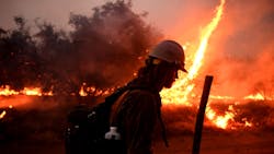 A firefighter helps to set back fires as the El Dorado Fire approaches Tucaipa, CA, on Monday.
