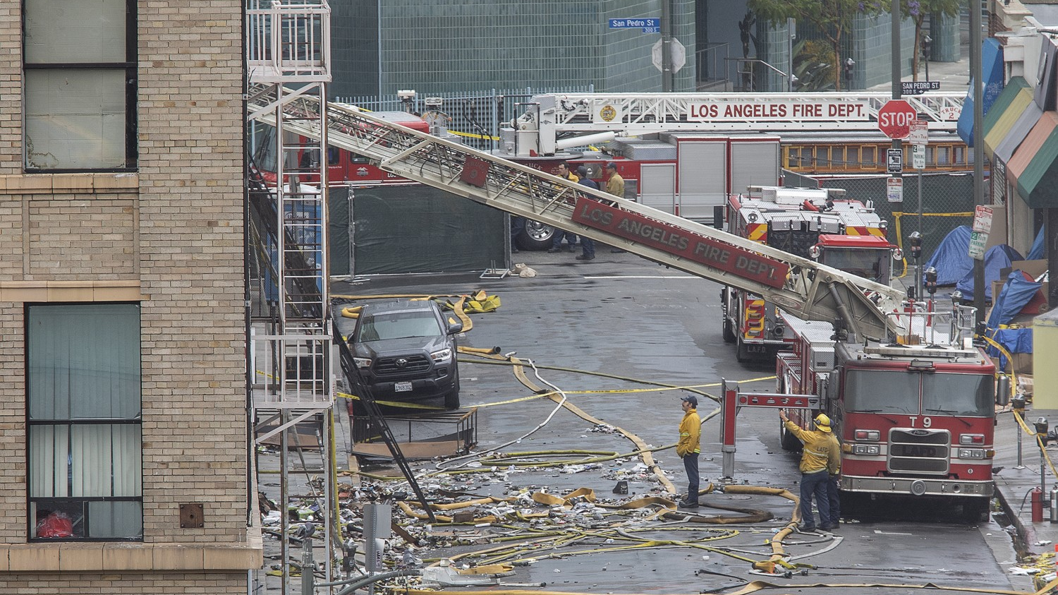 Members of the Los Angeles Fire Department investigate the scene of a fiery explosion on in the city's Toy District that severely burned 11 firefighters and damaged buildings and fire equipment, authorities said.