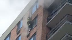 An FDNY firefighter reaches a woman on the 16th floor during a high-rise fire in Harlem on Tuesday. An FDNY firefighter reaches a woman on the 16th floor during a high-rise fire in Harlem on Tuesday.
