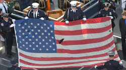 A U.S. flag recovered from the 9/11 attacks is displayed by New York City police officers and firefighters during the ceremony marking the 10th anniversary of the terrorist attack in 2011.