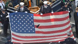 A U.S. flag recovered from the 9/11 attacks is displayed by New York City police officers and firefighters during the ceremony marking the 10th anniversary of the terrorist attack in 2011.