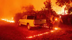 Firefighters light backfire around a vehicle during the Bear fire, part of the North Lightning Complex fires, in the Berry Creek area of unincorporated Butte County, CA, on Sept. 9, 2020.