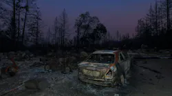 Charred remains of a structure and a vehicle hit by the CZU Lightning Complex fire in Boulder Creek, CA.