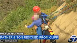 A San Francisco firefighter carries a young boy to safety after he and his father became trapped on a cliffside during a hike on Saturday, Sept. 19, 2020.