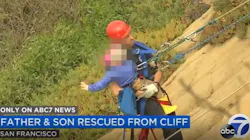 A San Francisco firefighter carries a young boy to safety after he and his father became trapped on a cliffside during a hike on Saturday, Sept. 19, 2020.