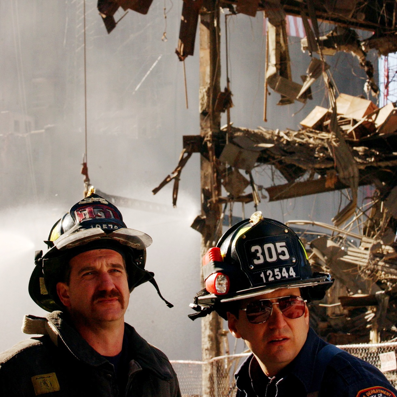 FDNY firefighters watch and listen to the World Trade Center Family Memorial Service at Ground Zero in New York City on Oct. 28, 2001.
