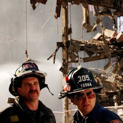FDNY firefighters watch and listen to the World Trade Center Family Memorial Service at Ground Zero in New York City on Oct. 28, 2001. FDNY firefighters watch and listen to the World Trade Center Family Memorial Service at Ground Zero in New York City on Oct. 28, 2001.