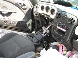 Figure 4. The interior of the two-door convertible shows not only frontal airbag deployment but significant bending of the steering wheel ring and total failure of the steering column mounting bracket.