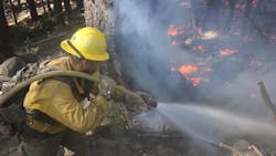A U.S. Forest Service engine crew member sprays down flames on the northwest flank of the August Complex Fire, above Ruth Valley, CA, on Sept. 22.