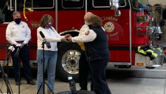 Jill Halsey (left) receives her father's retirement badge from members of the Clayton, MO, Fire Department. Halsey's father was the city's first fire marshal, and the badge was lost years ago in Florida.