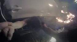 Davis, CA, Police Cpl. Pheng Ly pulls a driver from her overturned car moments after a fiery crash along Interstate 80 on Saturday. The dramatic rescue was captured by Ly's body and dashboard cameras.