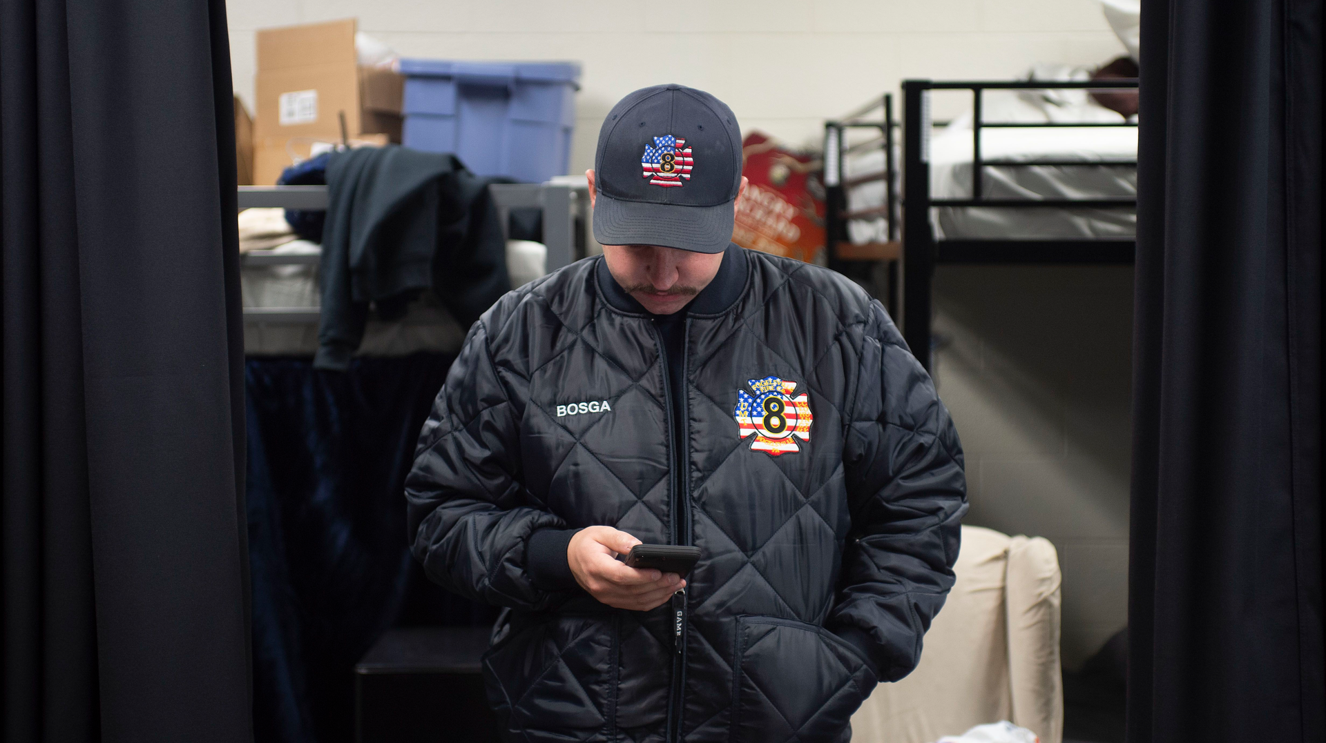 Fogelsville, PA, Volunteer Fire Company live-in firefighter Nick Bosga checks his smartphone outside the sleeping quarters.