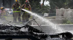 Firefighters work to put out a fire aboard a boat on the New River in Fort Lauderdale, FL, on Thursday that injured at least 13 people.