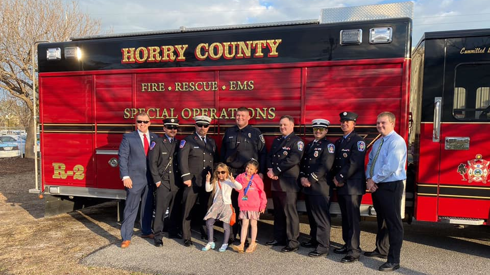 Horry County, SC, volunteer firefighter and Myrtle Beach Police Officer Jacob Hancher (center).