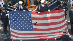 A U.S. flag recovered from the 9/11 attacks is displayed by New York City police officers and firefighters during the ceremony marking the 10th anniversary of the terrorist attack in 2011.