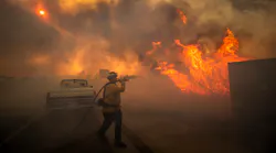 Firefighter Raymond Vasquez braves tall flames as he fights the advancing Silverado Fire, fueled by Santa Ana winds, at the 241 toll road and Portola Parkway in Irvine, CA, on Monday.