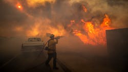 Firefighter Raymond Vasquez braves tall flames as he fights the advancing Silverado Fire, fueled by Santa Ana winds, at the 241 toll road and Portola Parkway in Irvine, CA, on Monday.