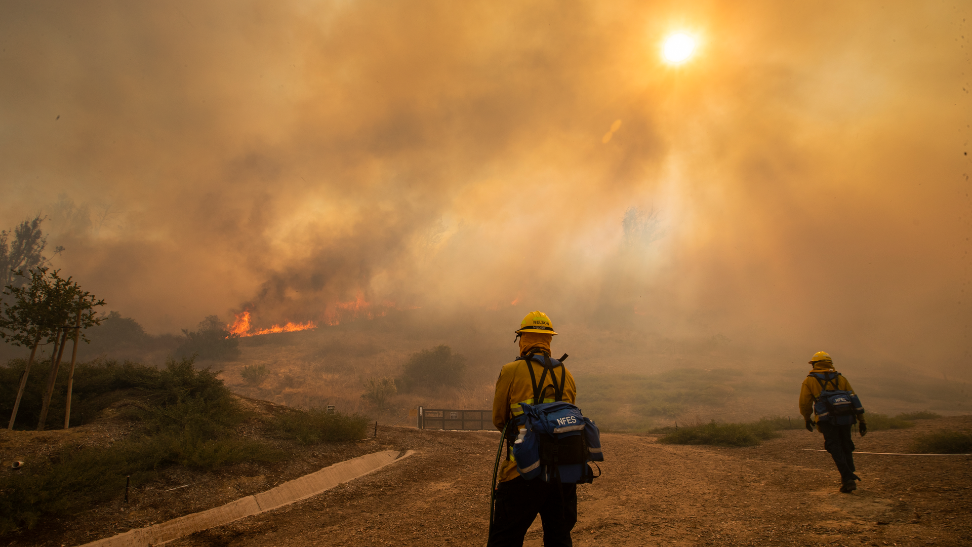 Orange County, CA, Fire Authority firefighters defend homes as the Silverado Fire approaches in an Orchard Hills neighborhood of Irvine on Monday.
