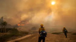 Orange County, CA, Fire Authority firefighters defend homes as the Silverado Fire approaches in an Orchard Hills neighborhood of Irvine on Monday.