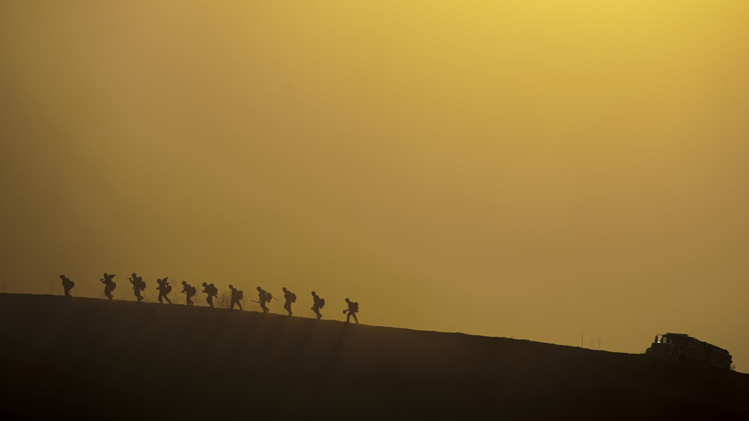 Wildland firefighters make their way up a hill through smoke in Chino Hills, CA, on Tuesday, Oct. 27, 2020.