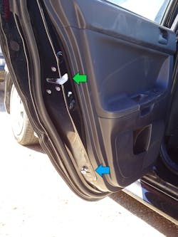 A close look at the end of the door reveals the familiar door safety latch (green arrow), which is mounted into the end of the door, with the short door striker pin (blue arrow) below.