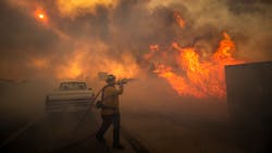 Firefighter Raymond Vasquez braves tall flames as he fights the advancing Silverado Fire in Irvine, CA, on Oct. 26, 2020. Firefighter Raymond Vasquez braves tall flames as he fights the advancing Silverado Fire in Irvine, CA, on Oct. 26, 2020.